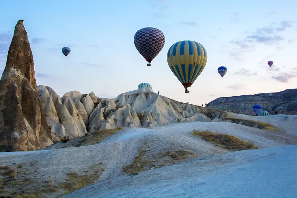 Two hot-air balloons beside a rock pinnacle in Cappadocia