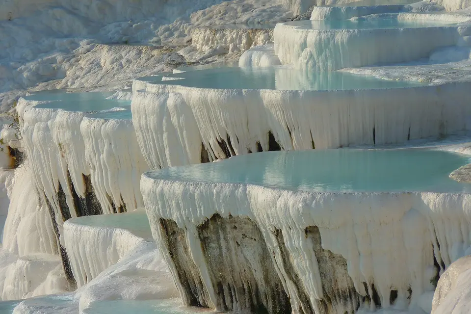 Close-up of the white calcium terraces and blue water of Pamukkale